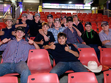 A large group of teenagers smiling and giving thumbs up at Sydney Royal Easter Show's Evening Entertainment event.